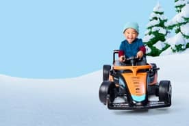 Boy shown driving ride-on car toy.