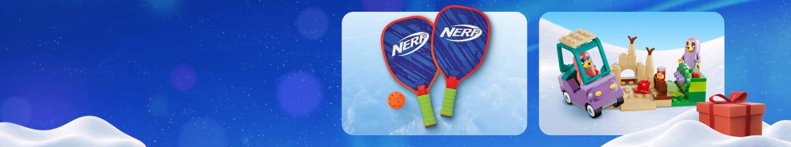 Nerf rackets with ball and a colorful toy vehicle with figures and reindeer beside a red gift box on a snowy holiday banner.