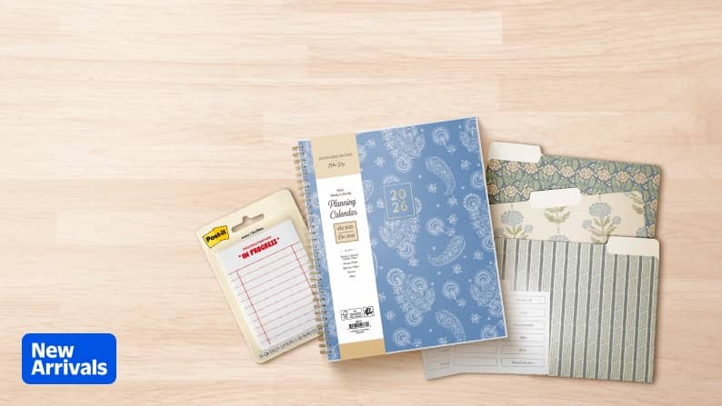 A blue notebook, stylish folders and Post-it mini list sticky notes are seen next to the words: New Arrivals.