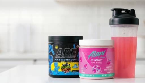 ABE Sour Patch Kids preworkout, Alani pre-workout next to a blender cup.