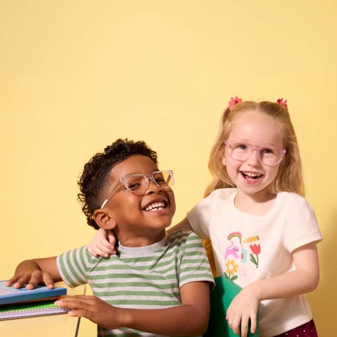 Two children wearing glasses and smiling.