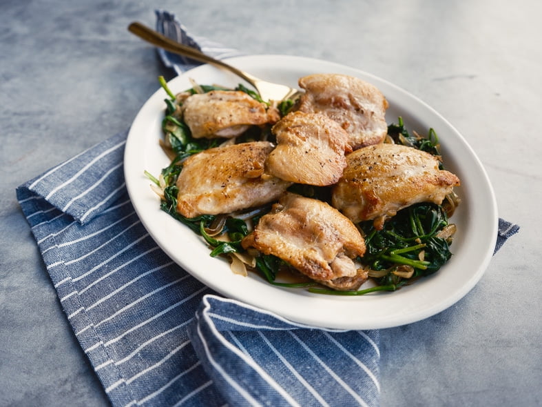 Crispy chicken thighs with spinach and shallot
