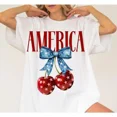 thumbnail image 1 of 100% Cotton oversized tshirt women American Flag Cherry Bow T-Shirt, Fourth of July, Patriotic Tee, Independence Day, American Flag Themed, Holiday Outfit Golf Gift T-Shirt For Men and Women, 1 of 10
