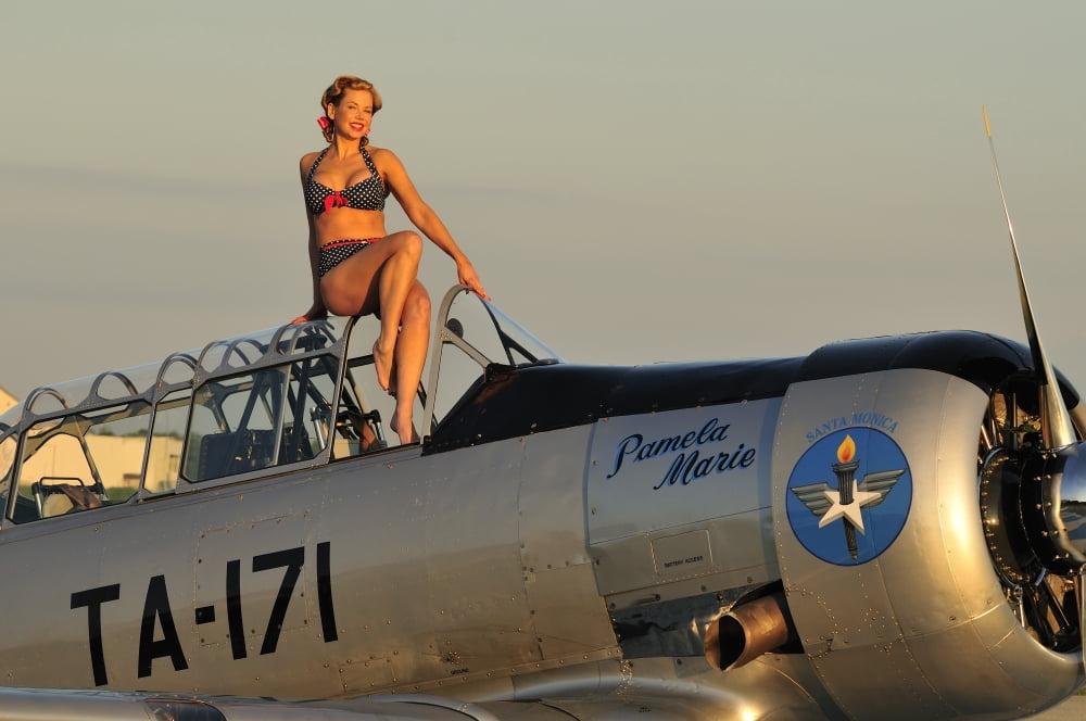 1940s style pin-up girl sitting on the cockpit of a World War II T-6 Texan Canvas Art - Christian KiefferStocktrek Images (18 x 12)