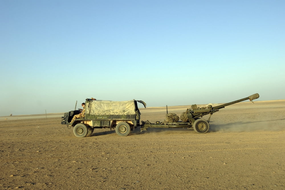 A 105mm light gun being towed by a Pinzgauer all-terrain vehicle Canvas Art - Andrew ChittockStocktrek Images (34 x 23)