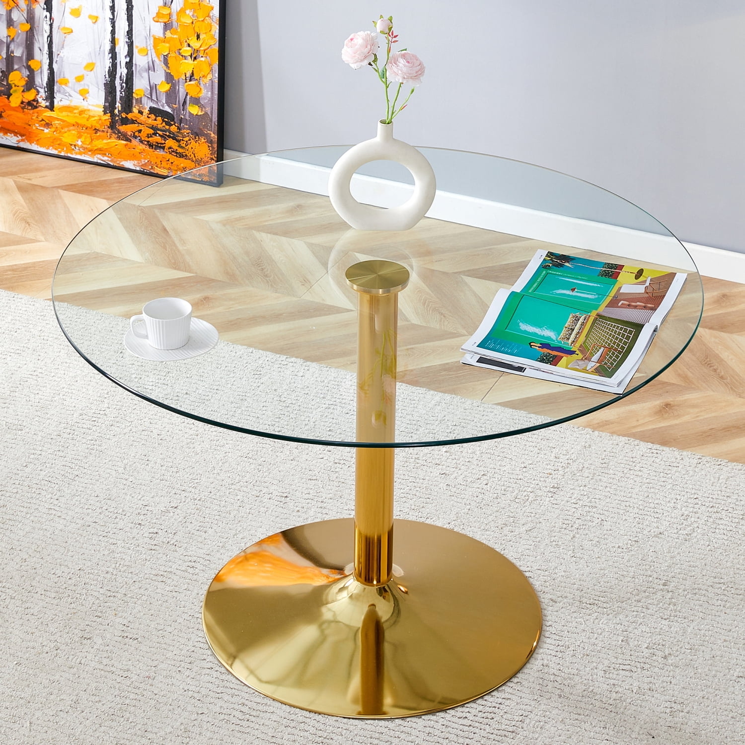 A 47-inch diameter glass top and a modern minimalist round dining table with gold metal legs ...