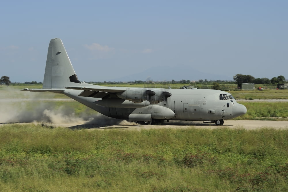 A C-130 Hercules of the Italian Air Force landing on an unpaved landing strip Canvas Art - Remo GuidiStocktrek Images (35 x 23)