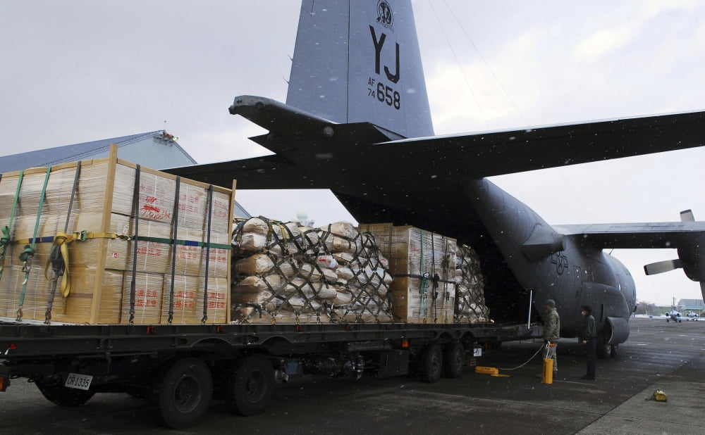 A C-130 Hercules prepares to transport humanitarian relief supplies Canvas Art - Stocktrek Images (36 x 22)