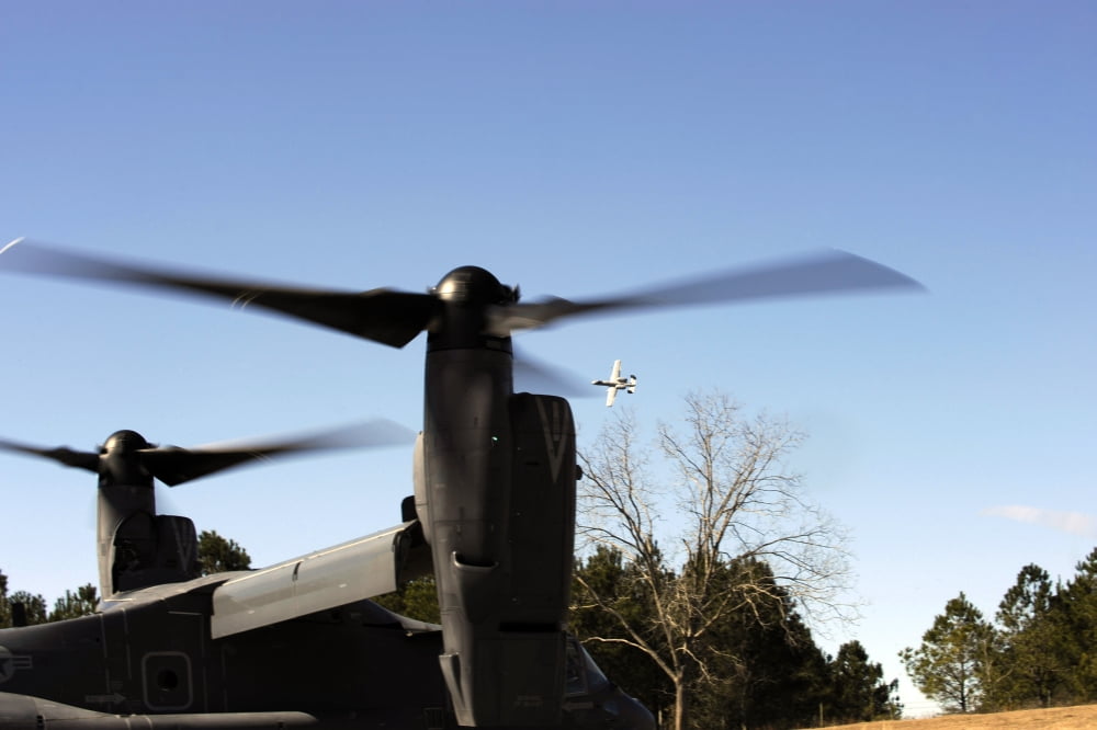 A CV-22 Osprey prepares to take off as an A-10 Thunderbolt II flies overhead Canvas Art - Stocktrek Images (34 x 23)