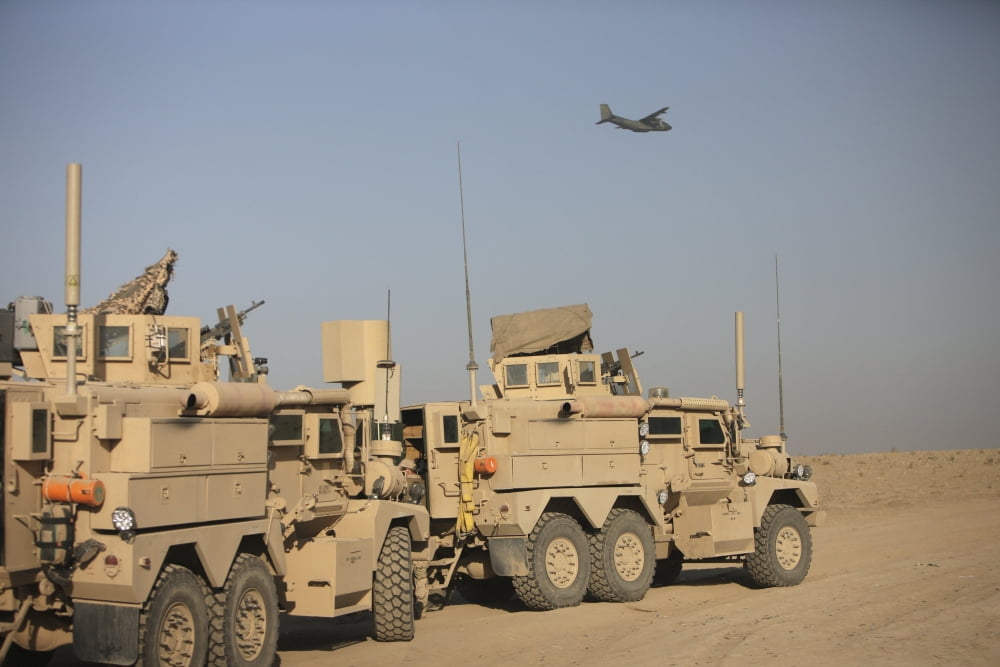 A German Transall C-160 flies over two EOD Cougar armored vehicles Canvas Art - Terry MooreStocktrek Images (18 x 12)