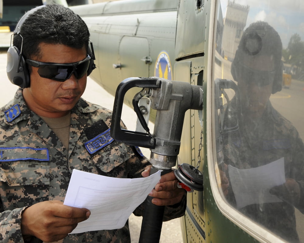 A Honduran crew chief consults his aircraft fueling checklist Canvas Art - Stocktrek Images (31 x 25)