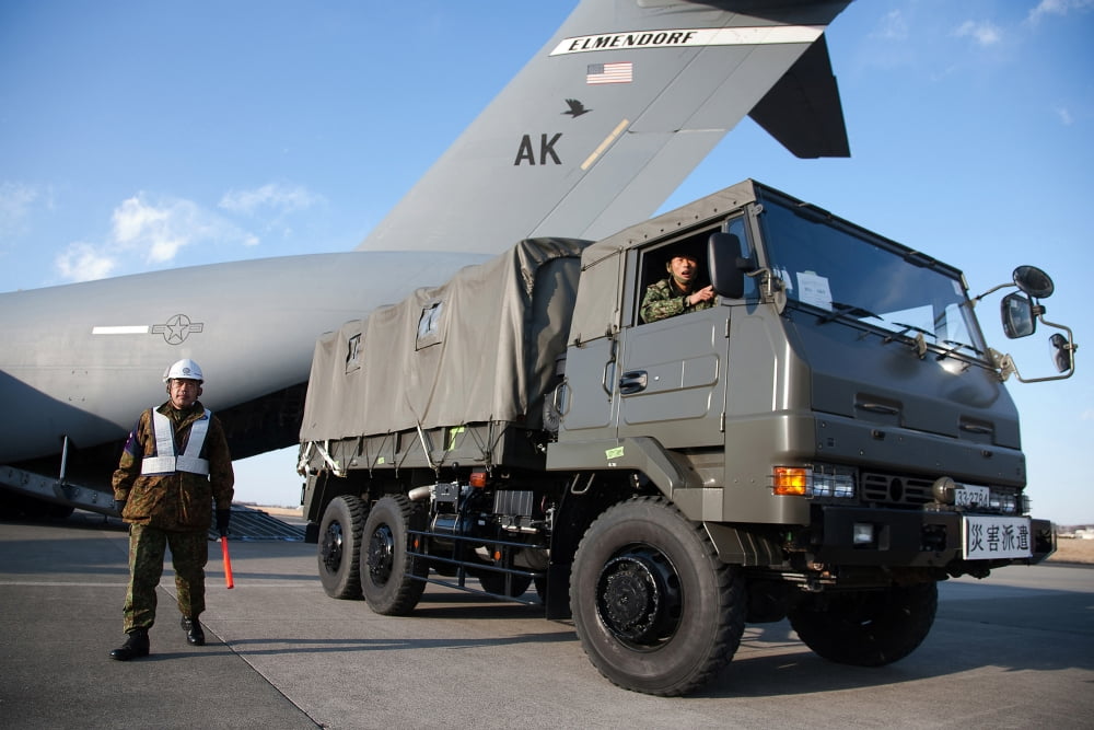 A Japanese soldier marshals vehicles from a C-17 Globemaster III Canvas Art - Stocktrek Images (34 x 23)