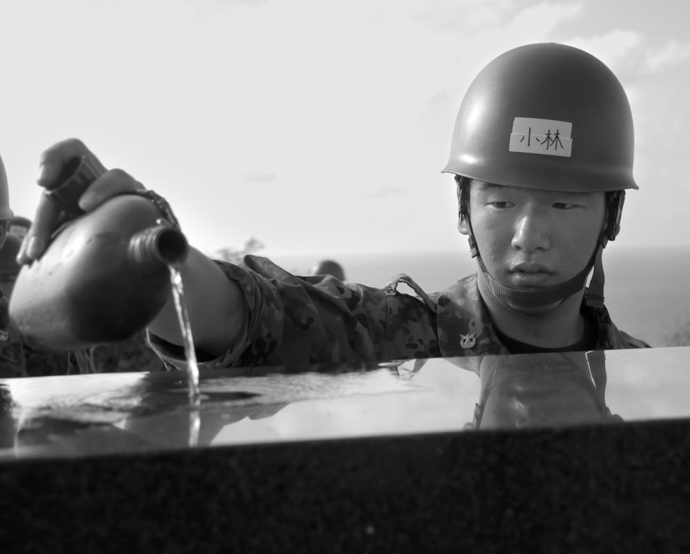 A Japanese soldier pours water on a Japanese monument Canvas Art - Stocktrek Images (31 x 25)