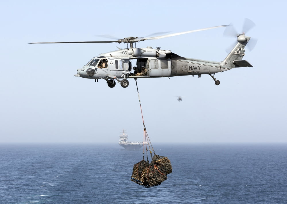 A MH-60 helicopter transfers cargo during a vertical replenishment Canvas Art - Gert KromhoutStocktrek Images (33 x 24)