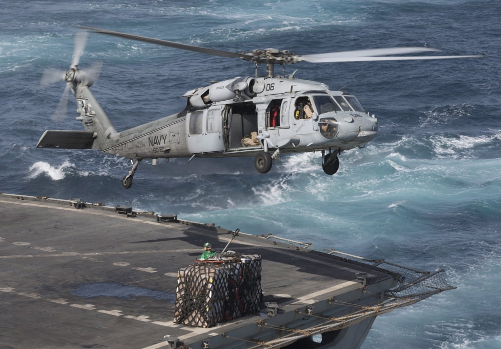 A MH-60S Knighthawk conducts a vertical replenishment at sea Canvas Art - Gert KromhoutStocktrek Images (17 x 12)