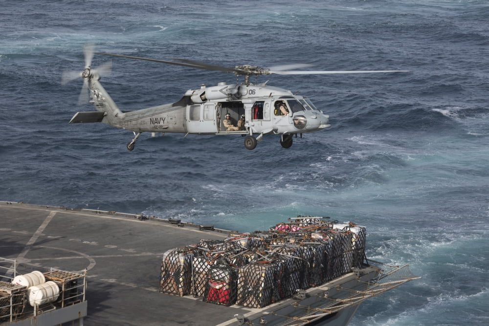 A MH-60S Knighthawk conducts a vertical replenishment at sea Canvas Art - Gert KromhoutStocktrek Images (18 x 12)
