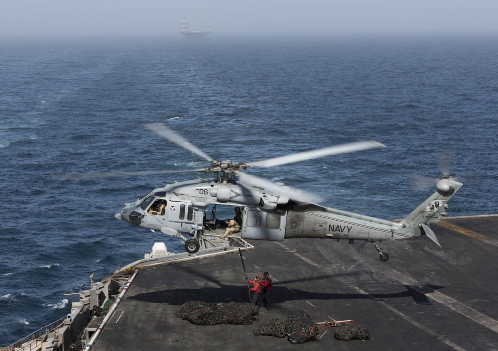 A MH-60S Knighthawk conducts a vertical replenishment at sea Canvas Art - Gert KromhoutStocktrek Images (34 x 24)