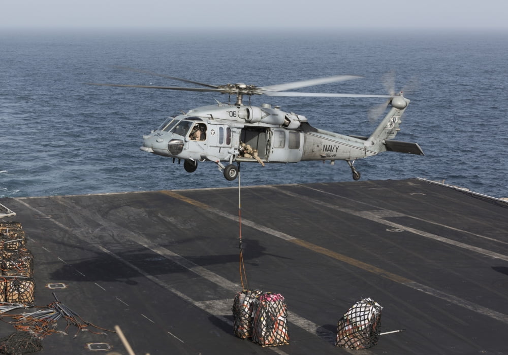 A MH-60S Knighthawk conducts a vertical replenishment at sea Canvas Art - Gert KromhoutStocktrek Images (34 x 24)