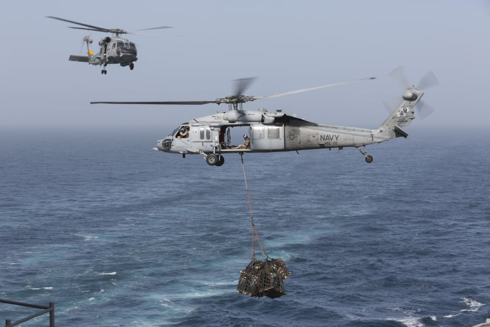 A MH-60S Knighthawk transfers cargo during a vertical replenishment Canvas Art - Gert KromhoutStocktrek Images (35 x 23)