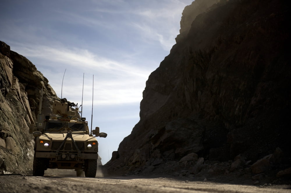 A MRAP vehicle drives through the mountains of Afghanistan Canvas Art - Stocktrek Images (34 x 23)