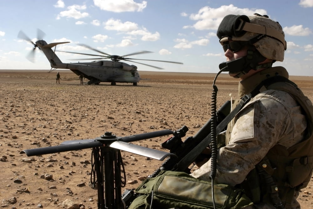A Marine assembles a radio antenna as a CH-53E Super Stallion helicopter lands nearby Canvas Art - Stocktrek Images (34 x 23)