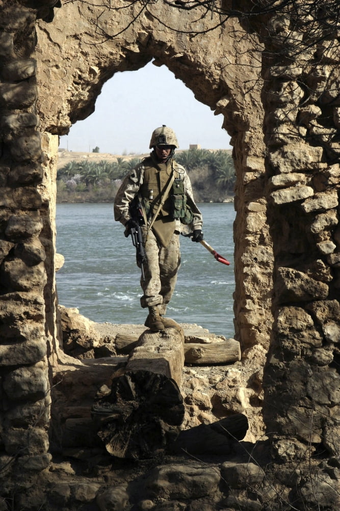 A Marine searching a stone aqueduct for weapons caches in Baghdad Iraq Canvas Art - Stocktrek Images (23 x 34)