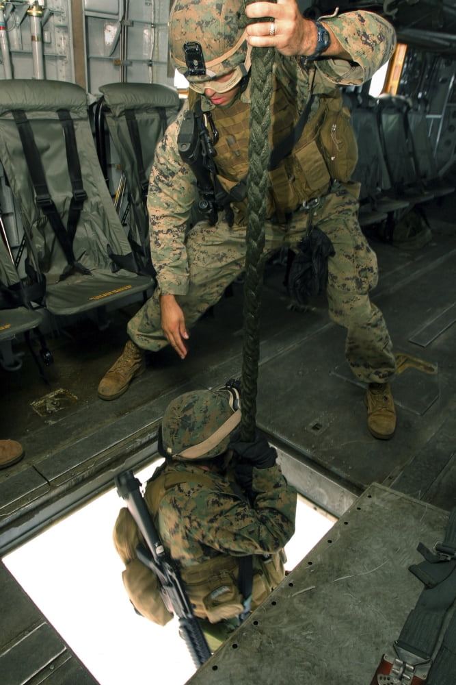 A Marine sends a fellow Marine down the hell hole of a CH-53E Super Stallion Canvas Art - Stocktrek Images (23 x 34)