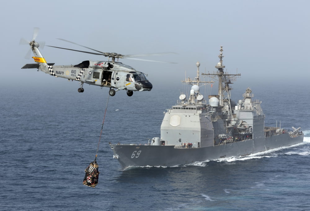 A SH-60J Seahawk flys by USS Vicksburg during a vertical replenishment Canvas Art - Gert KromhoutStocktrek Images (18 x 12)