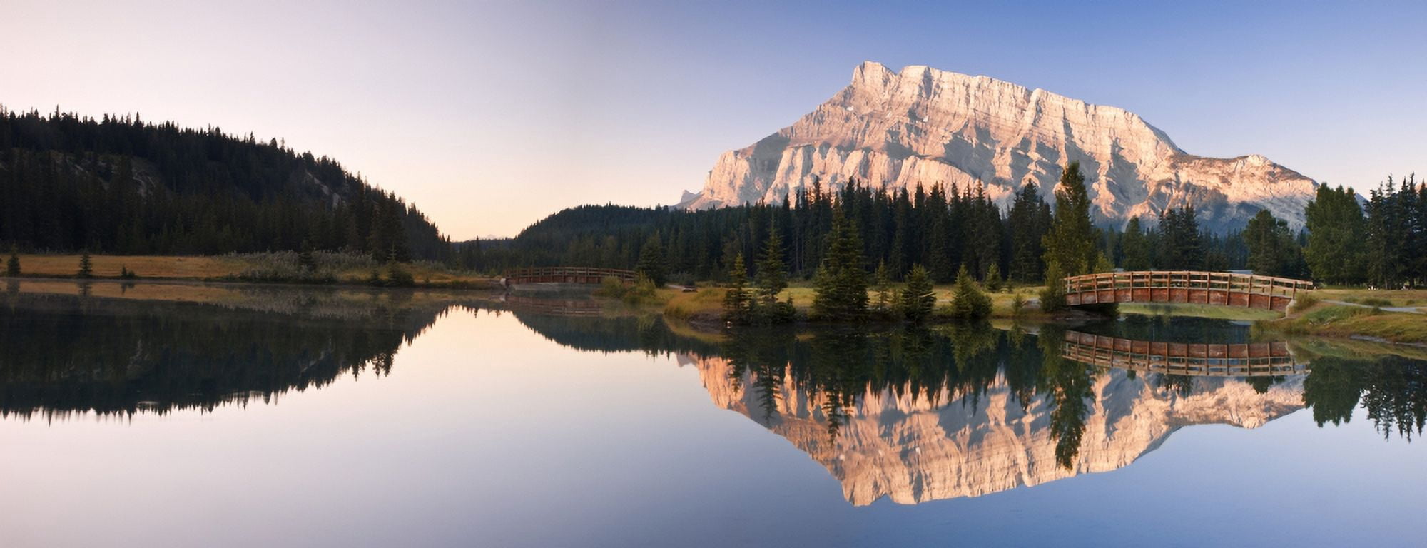 A Scenic Shot Of A Mountainside And Small Bridge Banff National ParkAlbertaCanada Canvas Art - Carson Ganci Design Pics (36 x 13)