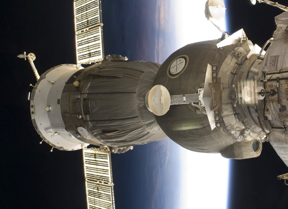 A Soyuz spacecraft backdropped by Earth Canvas Art - Stocktrek Images (33 x 24)