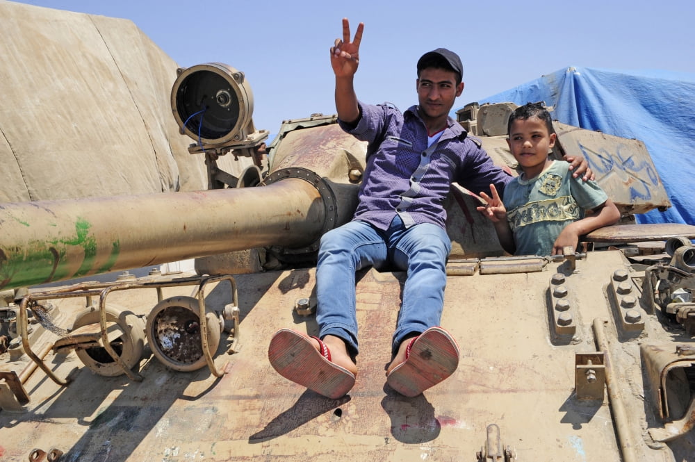 A T-55 tank with two children playing on it in Benghazi Libya Canvas Art - Andrew ChittockStocktrek Images (18 x 12)