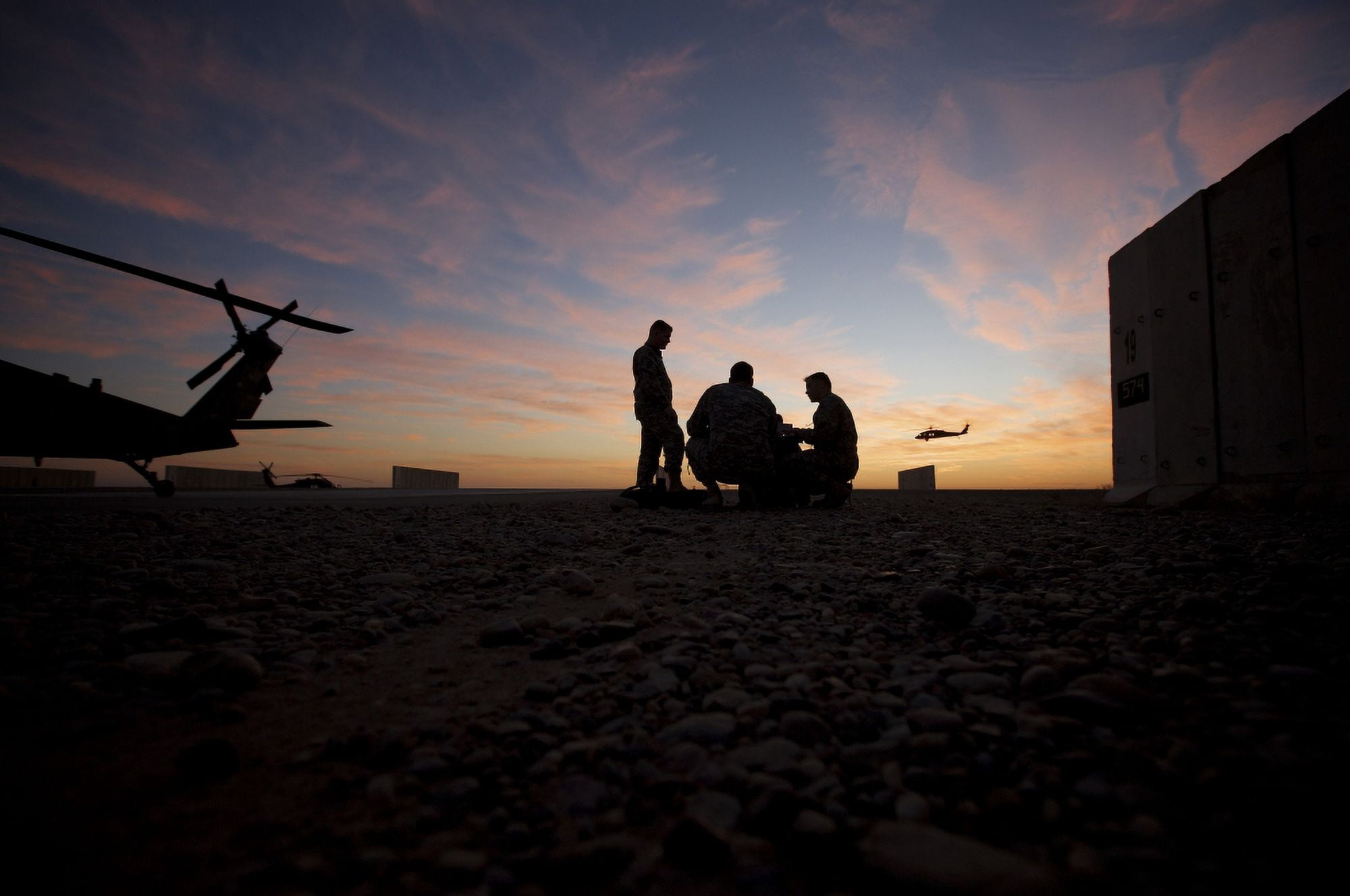 A UH-60 Black Hawk crew carry out a mission brief at sunset Canvas Art - Terry MooreStocktrek Images (18 x 12)