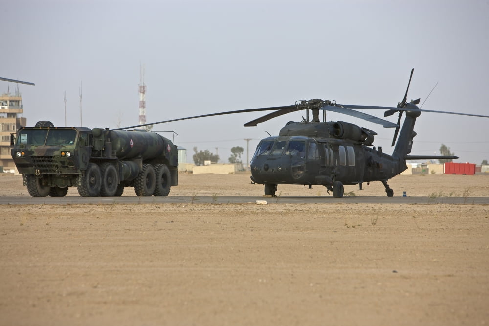 A UH-60 Black Hawk helicopter and its refueler truck Canvas Art - Terry MooreStocktrek Images (18 x 12)