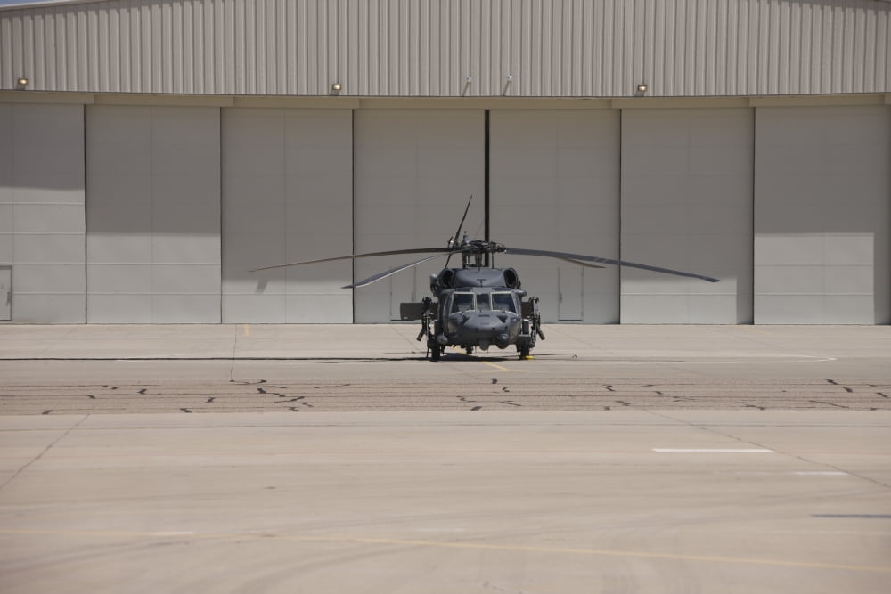 A UH-60 Black Hawk helicopter parked in front of a hanger Canvas Art - Terry MooreStocktrek Images (18 x 12)