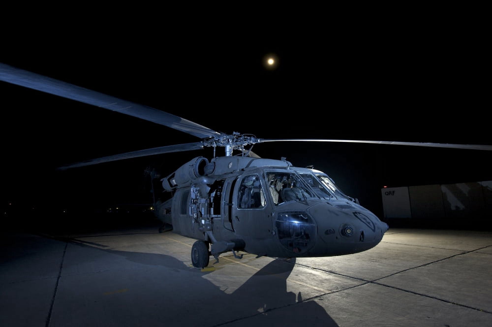 A UH-60 Black Hawk helicopter parked on the flight line under a full moon Canvas Art - Terry MooreStocktrek Images (18 x 12)