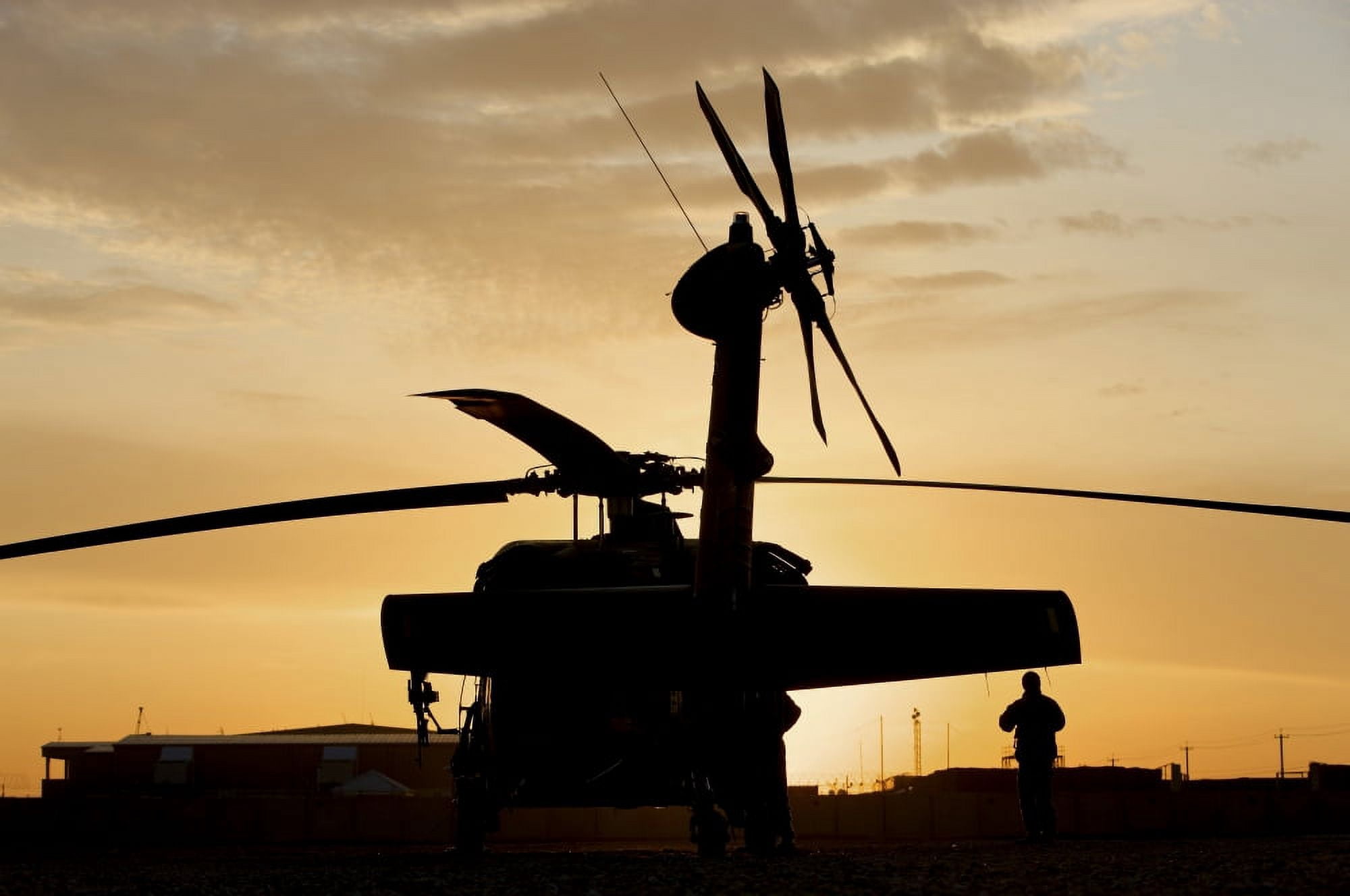 A UH-60L Black Hawk helicopter silhouetted by the setting sun Canvas Art - Terry MooreStocktrek Images (18 x 12)