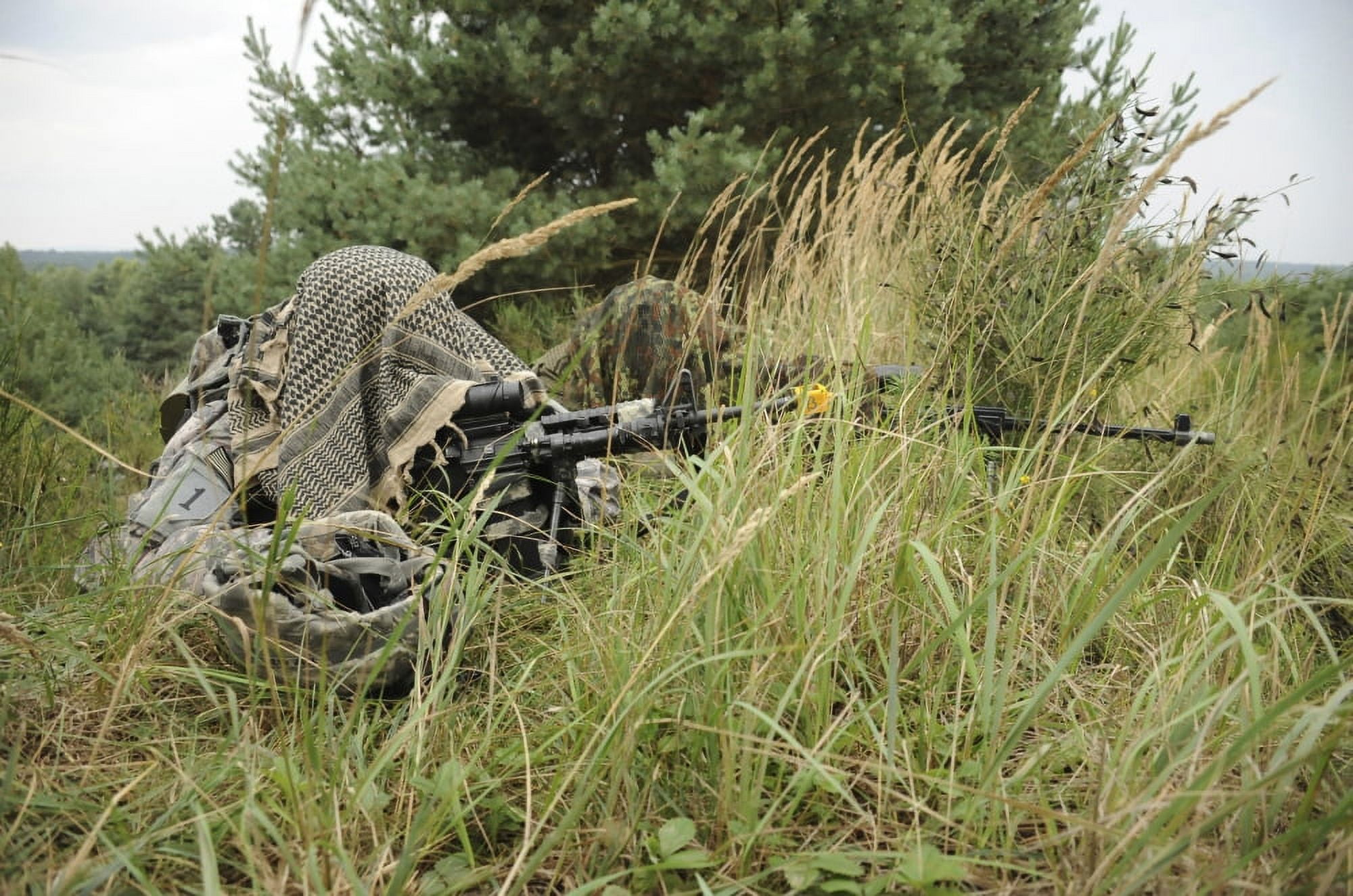 A US Army Soldier and a German Bundeswehr soldier camouflage themselves Canvas Art - Stocktrek Images (35 x 23)