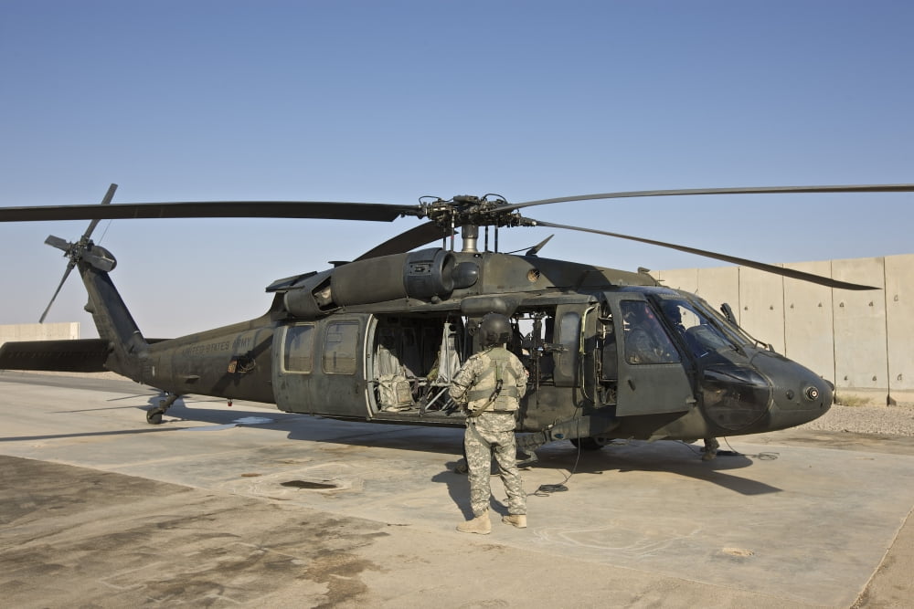 A US Army crew chief stands next to a UH-60 Black Hawk Canvas Art - Terry MooreStocktrek Images (35 x 23)