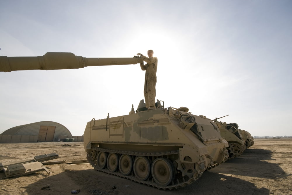 A US Army mechanic uses a M113 as a platform to boresight a M1 Abrams tank Canvas Art - Terry MooreStocktrek Images (35 x 23)