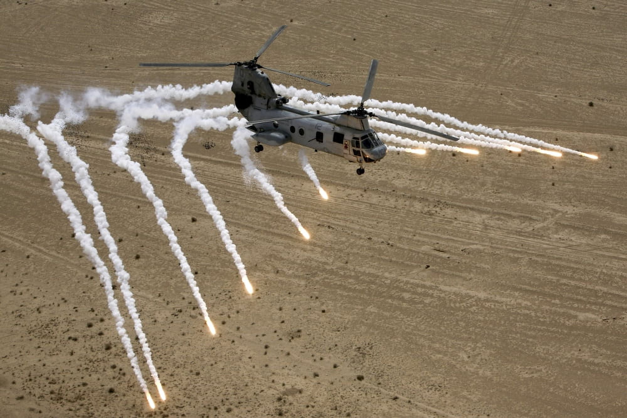 A US Marine Corps CH-46 Sea Knight helicopter launching flares over the desert near Al Taqqadum Iraq Canvas Art - Stocktrek Images (34 x 23)