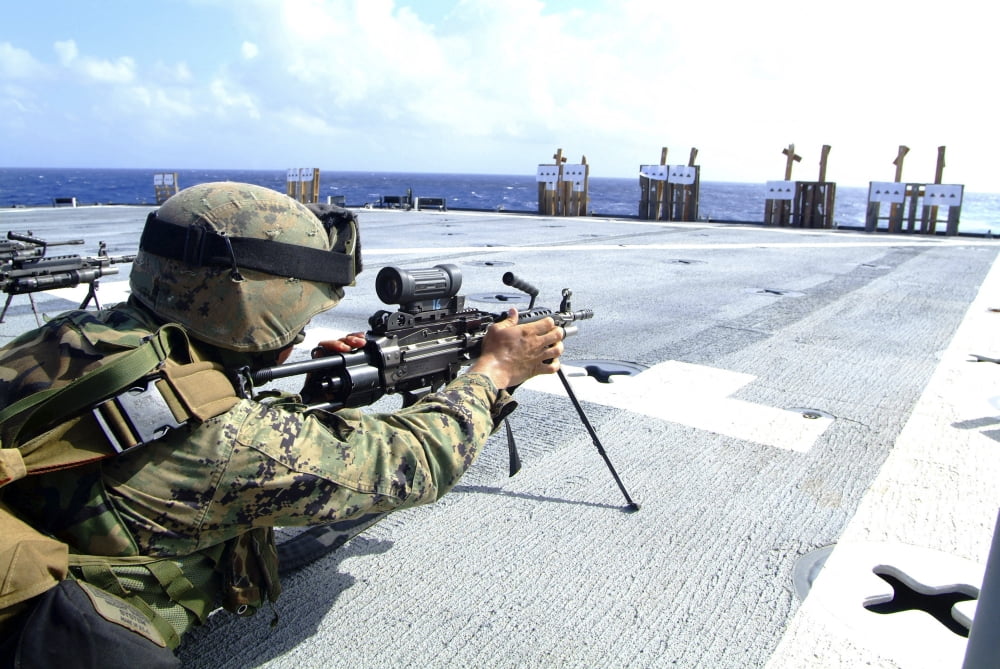 A US Marine adjusting his weapon on the flight deck of USS Harpers Ferry Canvas Art - Stocktrek Images (34 x 23)
