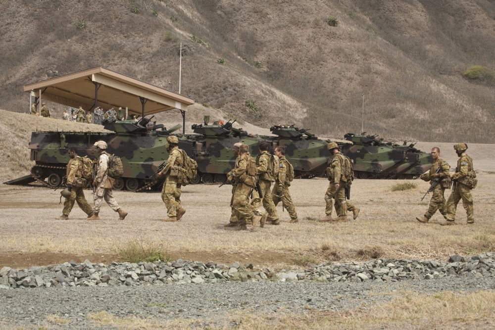 A US Marine and Australian soldiers walk past amphibious assault vehicles they used during a raid Canvas Art - Stocktrek Images (34 x 23)