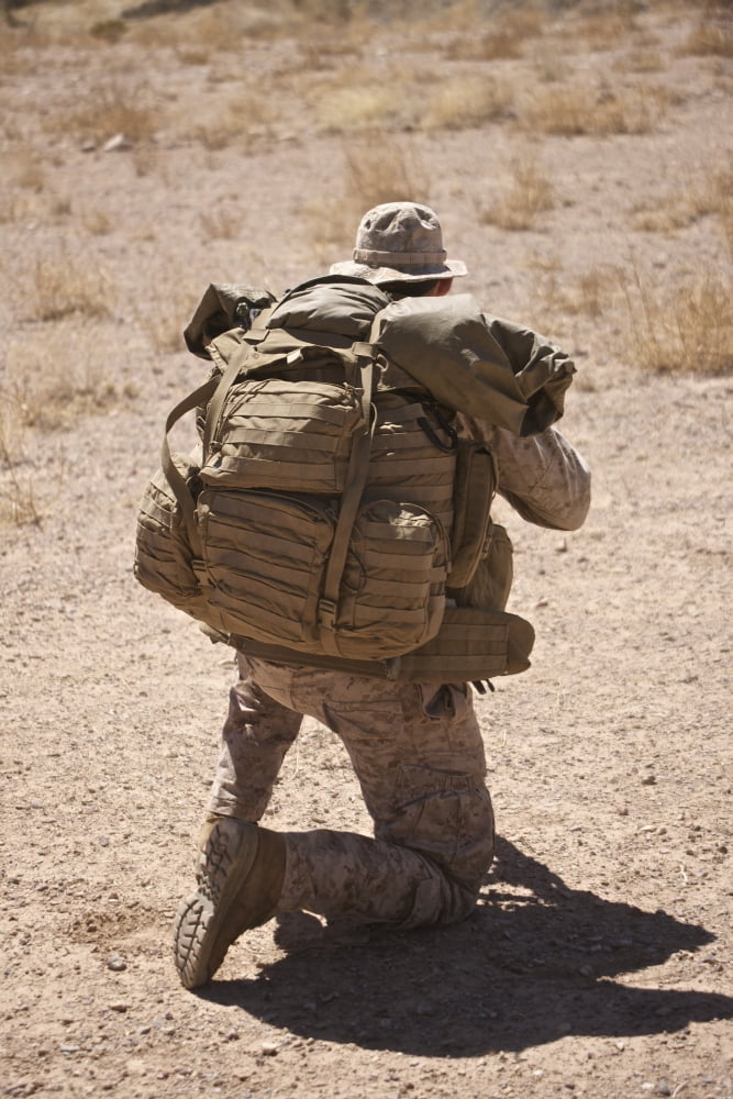 A US Marine pulls security while his team boards a UH-60 Black Hawk Canvas Art - Terry MooreStocktrek Images (12 x 18)