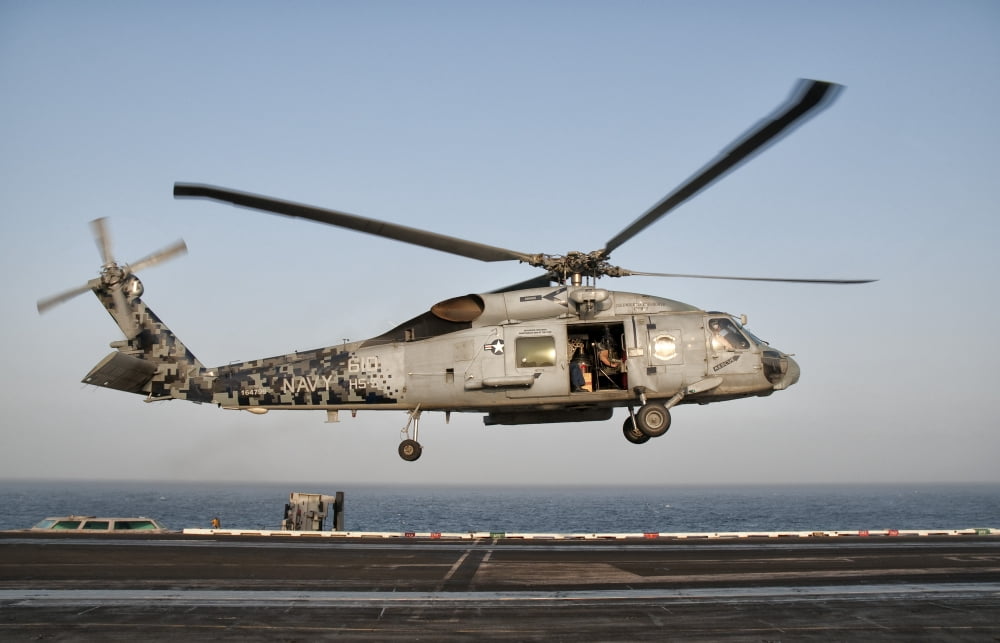 A US Navy SH-60F Seahawk hovers above the flight deck of USS Eisenhower Canvas Art - Giovanni CollaStocktrek Images (18 x 12)