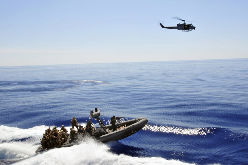 A US Navy UH-1N Huey helicopter provides cover for US Marines on a rigid hull inflatable boat Canvas Art - Stocktrek Images (35 x 23)