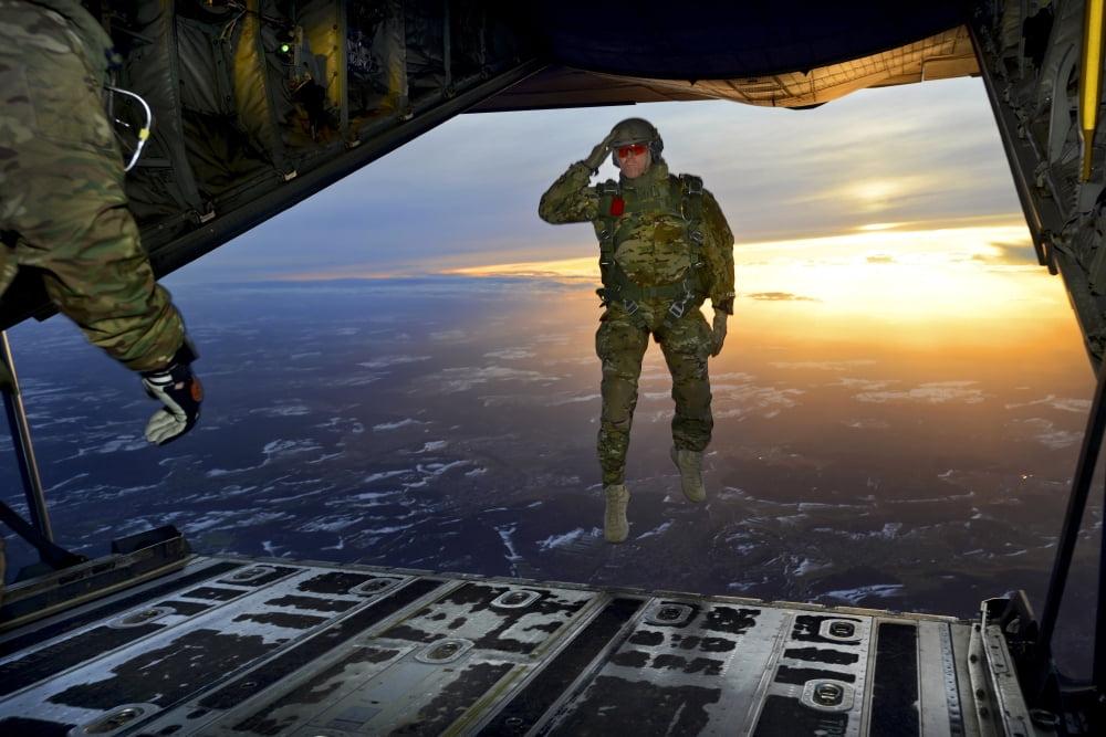 A US Soldier salutes his fellow Soldiers while jumping out of a C-130 Hercules Canvas Art - Stocktrek Images (34 x 23)
