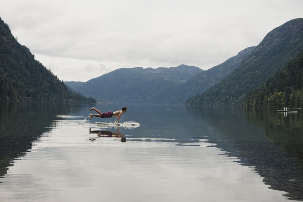 A Young Man Leaps Onto His Body Board In Cameron Lake British Columbia Canada Canvas Art - Helene Cyr Design Pics (19 x 12)
