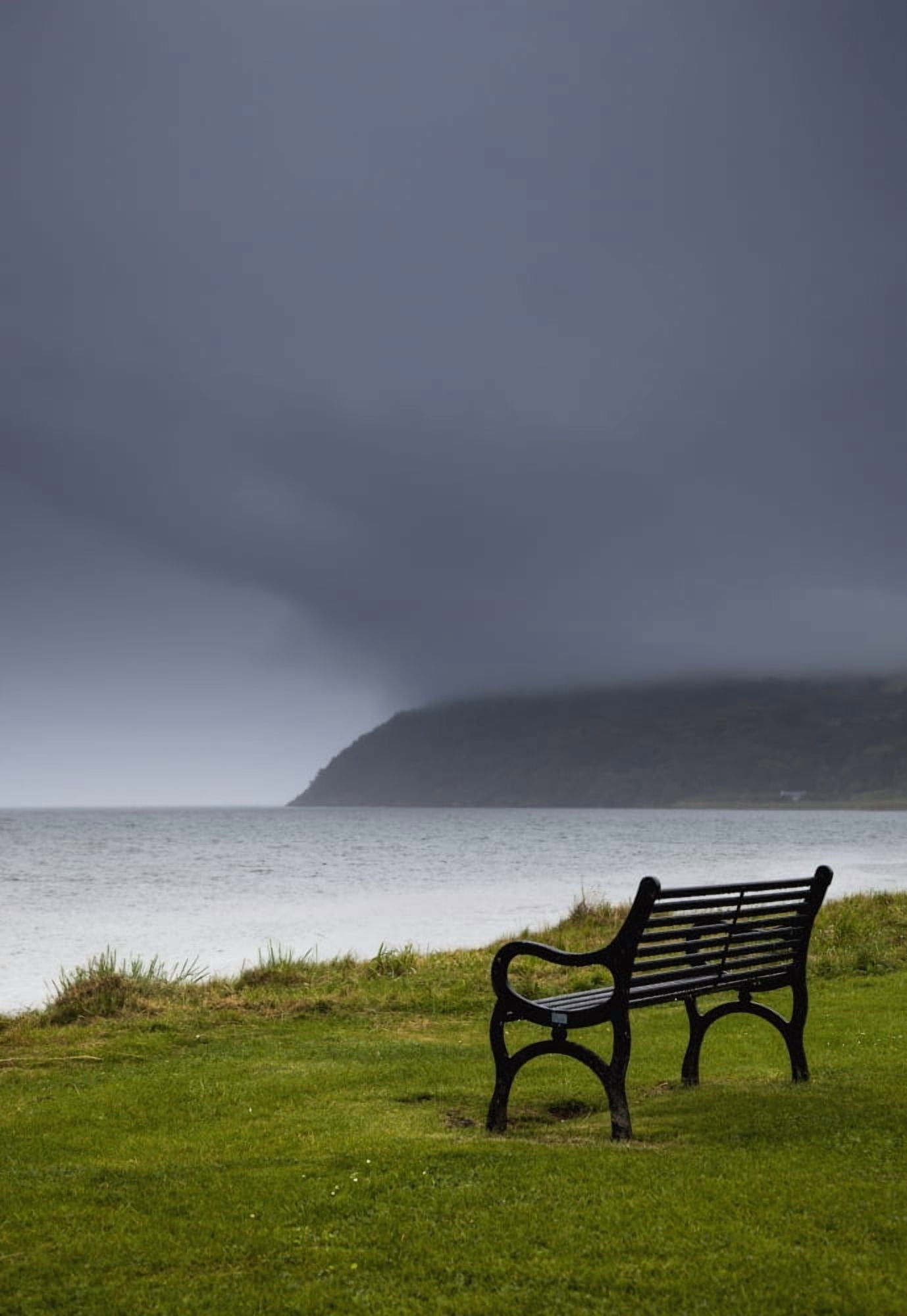 A bench at the waters edge with a dark stormy skyMoray firth scotland Canvas Art - John Short Design Pics (24 x 36)