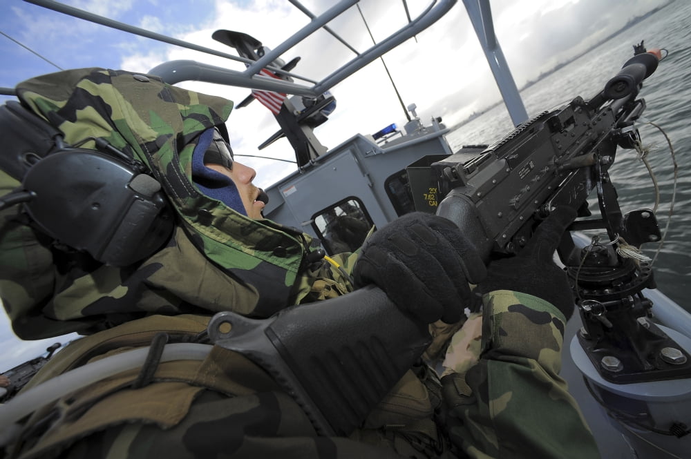 A boat crewman gunner mans an M-240B machine gun aboard a rigid-hull inflatable boat Canvas Art - Stocktrek Images (35 x 23)