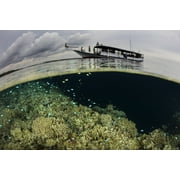 A boat sits atop a shallow coral reef thrives in Wakatobi National Park, Indonesia. Poster Print by Ethan Daniels/Stocktrek Images (34 x 23)